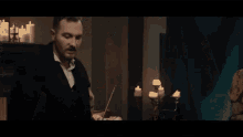 a man with a mustache is standing in front of a woman in a room .