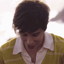 a close up of a man 's face with a yellow shirt on