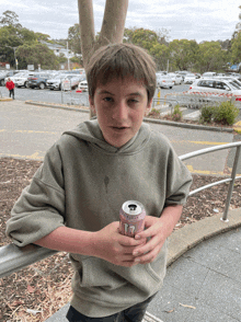 a young boy holds a can of t7 energy drink in his hands