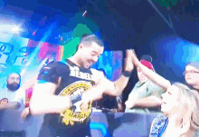 a man wearing a shirt that says ' reign ' on it is giving a high five