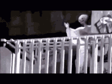 a man is standing on a balcony holding a white umbrella .