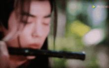 a close up of a person playing a flute with chinese characters on the bottom
