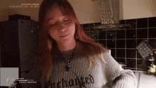 a woman wearing a grey sweater with the word " cheer " written on it