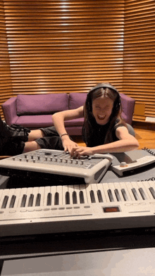 a girl wearing headphones is playing a keyboard