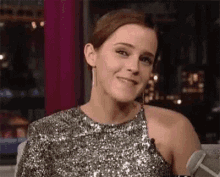 a woman in a sequined dress is smiling .