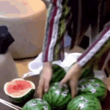 a bunch of watermelons are on a table with a slice of grapefruit
