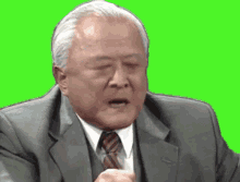 a man in a suit and tie is making a funny face on a green screen