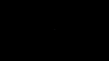 a man is holding a microphone in front of his face in the dark .