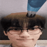 a man wearing glasses has a blue piping bag on his head