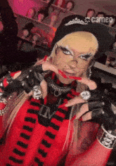 a woman wearing a red and black striped shirt and a cameo hat