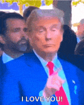 a man in a blue suit and red tie is saying i love you