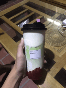 a person is holding a cup of drink with a label that says " mang ve " on it