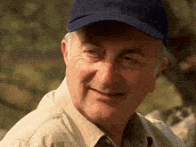 an older man wearing a blue hat is smiling for the camera