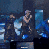 two men are singing into microphones on a stage with the words urrutiagifs written on the bottom