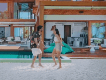 a man and a woman are dancing in front of a house