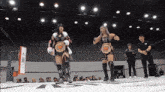 two women are standing in a wrestling ring and one has a belt that says x