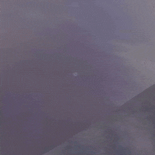 a man is flying through the air with his arms outstretched in a dark room .