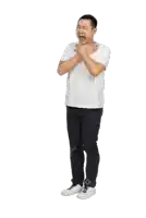 a man in a white shirt and black pants is covering his mouth