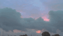 a cloudy sky with a red light in the distance