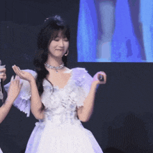 a woman in a white dress with ruffled sleeves is dancing