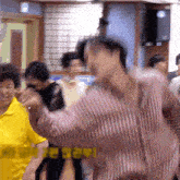 a group of people are dancing in a room with a sign that says i love you
