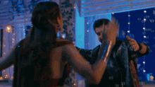 a man and a woman are dancing together in a room with lights .