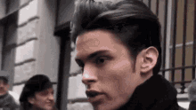 a close up of a man 's face with a man in a hat in the background