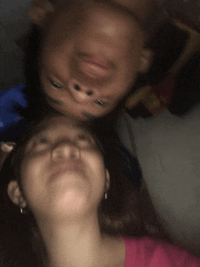 a blurry photo of two people 's faces with one making a funny face