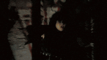 a person is standing next to a tree at night .
