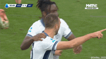 a group of soccer players are giving each other a high five in front of a screen that says match
