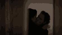 a woman standing in a dark room with a sign on the wall that says a