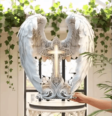 a statue of an angel with wings and a cross on it