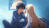 a boy and a girl are sitting on a bed and the girl is touching the boy 's nose