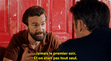 a man with a beard is talking to another man with the words " jamais le premier soir " on the bottom