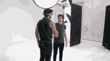 two men are shaking hands in a photo studio .