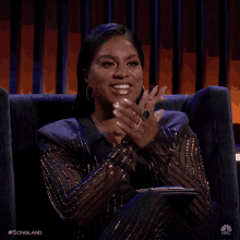 a woman sits in a chair with her hands together and the words songland on the bottom right
