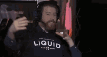 a man is wearing headphones and a shirt that says liquid