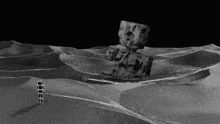 a black and white photo of a desert with a cube in the middle