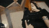 a man is holding a gun in his hand and smoking a cigarette in a room .