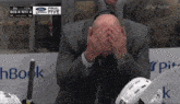 a man covering his face during a hockey game with bos 4 ny 4