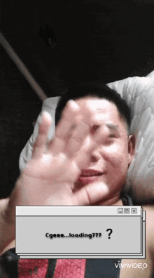 a man laying on a bed with his hand up and a box that says loading