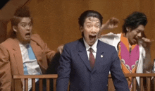 a group of men in suits and ties are standing in a courtroom with their mouths open