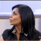 a woman with long black hair is making a funny face while sitting on a chair .