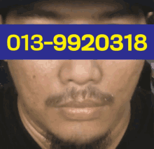 a close up of a man 's face with the phone number 013-9920318 visible