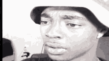 a black and white photo of a man wearing a hat and ear buds