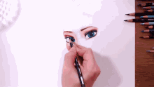 a person is drawing a woman 's face with colored pencils on a piece of paper .