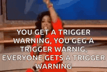 a woman in a red dress is dancing with her arms in the air and a warning .