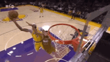 a basketball player is jumping in the air to dunk the ball during a game