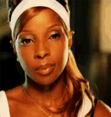 a close up of a woman wearing a headband and necklace .