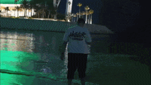 a man in a hollister t-shirt stands in the water